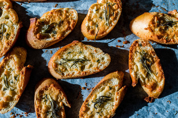 Garlic Parmesan Cheese Bread Slices on Baking Paper Sheet with Oven Tray. Freshly Baked.
