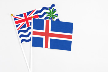 Iceland and British Indian Ocean Territory stick flags on white background. High quality fabric, miniature national flag. Peaceful global concept.White floor for copy space.