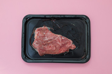 frozen meat on black plastic dish