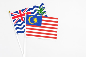 Malaysia and British Indian Ocean Territory stick flags on white background. High quality fabric, miniature national flag. Peaceful global concept.White floor for copy space.