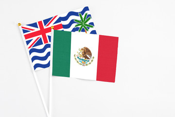 Mexico and British Indian Ocean Territory stick flags on white background. High quality fabric, miniature national flag. Peaceful global concept.White floor for copy space.