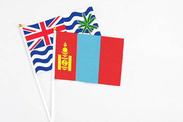 Fototapeta premium Mongolia and British Indian Ocean Territory stick flags on white background. High quality fabric, miniature national flag. Peaceful global concept.White floor for copy space.