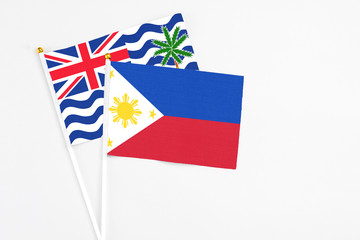 Philippines and British Indian Ocean Territory stick flags on white background. High quality fabric, miniature national flag. Peaceful global concept.White floor for copy space.