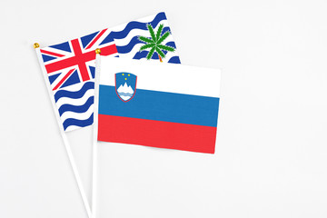Slovenia and British Indian Ocean Territory stick flags on white background. High quality fabric, miniature national flag. Peaceful global concept.White floor for copy space.