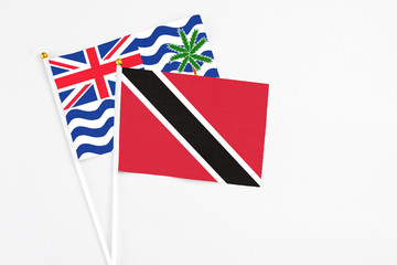 Trinidad And Tobago and British Indian Ocean Territory stick flags on white background. High quality fabric, miniature national flag. Peaceful global concept.White floor for copy space.