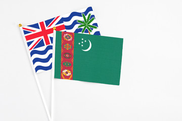Turkmenistan and British Indian Ocean Territory stick flags on white background. High quality fabric, miniature national flag. Peaceful global concept.White floor for copy space.