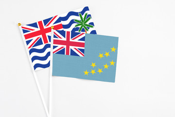 Fototapeta premium Tuvalu and British Indian Ocean Territory stick flags on white background. High quality fabric, miniature national flag. Peaceful global concept.White floor for copy space.
