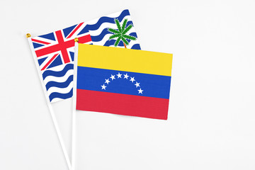 Venezuela and British Indian Ocean Territory stick flags on white background. High quality fabric, miniature national flag. Peaceful global concept.White floor for copy space.