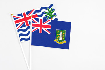 Fototapeta premium British Virgin Islands and British Indian Ocean Territory stick flags on white background. High quality fabric, miniature national flag. Peaceful global concept.White floor for copy space.