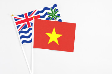 Vietnam and British Indian Ocean Territory stick flags on white background. High quality fabric, miniature national flag. Peaceful global concept.White floor for copy space.