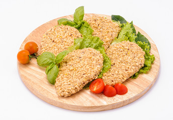 Cotolette di pollo su tagliere di legno