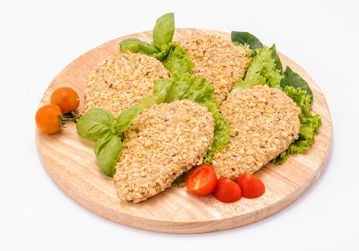 Cotolette di pollo su tagliere di legno