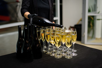 Waiter pours champagne into the glasses