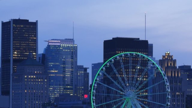 Time lapse, Ferris wheel rotating, Montreal downtown, old port view, buildings, skyscrapers and beautiful sunset time view, day to night timelapse.