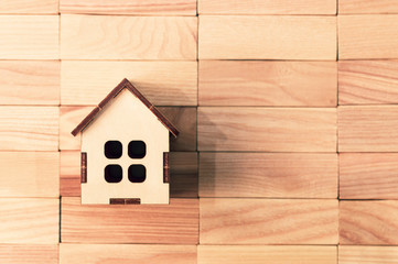 Obraz na płótnie Canvas toy wooden house on wooden background, space for text, mock up