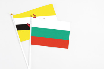 Bulgaria and Brunei stick flags on white background. High quality fabric, miniature national flag. Peaceful global concept.White floor for copy space.