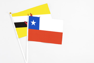 Chile and Brunei stick flags on white background. High quality fabric, miniature national flag. Peaceful global concept.White floor for copy space.