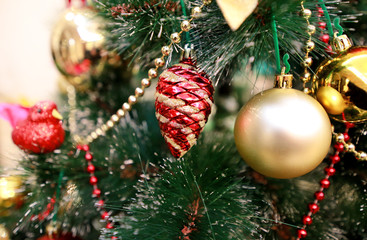 New Years colorful decoration ornaments on Christmas tree. Room decorated to christmas celebration, holiday scene with various shapes, multicolored balls, decorative sparkle bows and bird on tree.