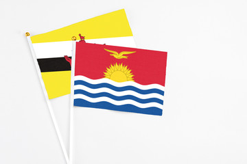 Kiribati and Brunei stick flags on white background. High quality fabric, miniature national flag. Peaceful global concept.White floor for copy space.