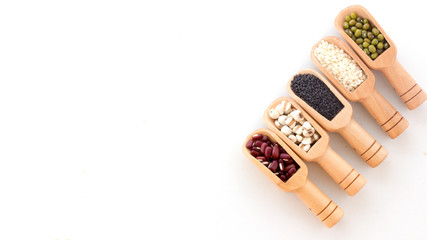 Flat lay composition of organic whole grains seeds or natural cereal in wooden scoop isolated on white background