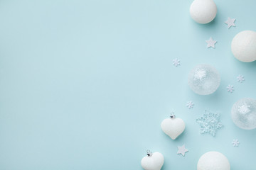 White Christmas decorations on mint pastel background. Christmas or New year holiday card top view. Minimalistic flat lay style.