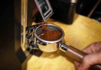 Fototapeta na wymiar Macro shot grinding coffee on professional grinder machine