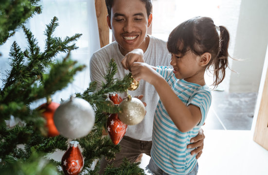 Asian Father And Daughter Installing Newly Bought Artificial Christmas Tree At Home