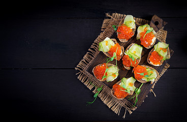 Canape with salmon red caviar. Sandwich for lunch. Delicious food. Top view, overhead