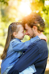 Family life. Portrait of dad and daughter in the Park. They pressed their foreheads together.