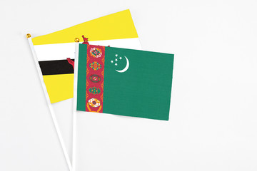 Turkmenistan and Brunei stick flags on white background. High quality fabric, miniature national flag. Peaceful global concept.White floor for copy space.