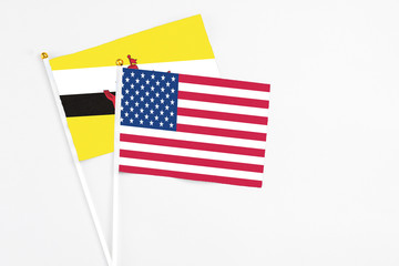 United States and Brunei stick flags on white background. High quality fabric, miniature national flag. Peaceful global concept.White floor for copy space.