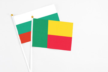 Benin and Bulgaria stick flags on white background. High quality fabric, miniature national flag. Peaceful global concept.White floor for copy space.
