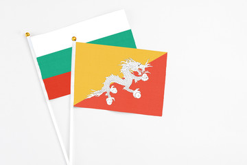 Bhutan and Bulgaria stick flags on white background. High quality fabric, miniature national flag. Peaceful global concept.White floor for copy space.