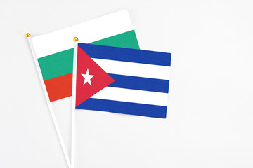 Cuba and Bulgaria stick flags on white background. High quality fabric, miniature national flag. Peaceful global concept.White floor for copy space.