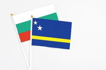 Curacao and Bulgaria stick flags on white background. High quality fabric, miniature national flag. Peaceful global concept.White floor for copy space.