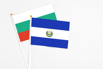 El Salvador and Bulgaria stick flags on white background. High quality fabric, miniature national flag. Peaceful global concept.White floor for copy space.