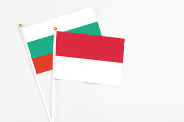 Indonesia and Bulgaria stick flags on white background. High quality fabric, miniature national flag. Peaceful global concept.White floor for copy space.