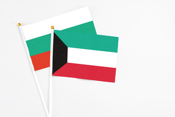 Kuwait and Bulgaria stick flags on white background. High quality fabric, miniature national flag. Peaceful global concept.White floor for copy space.