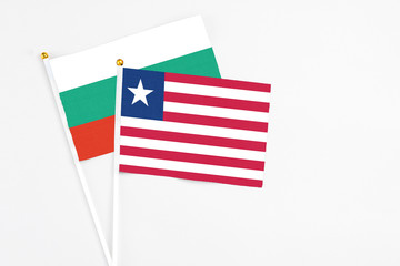 Liberia and Bulgaria stick flags on white background. High quality fabric, miniature national flag. Peaceful global concept.White floor for copy space.