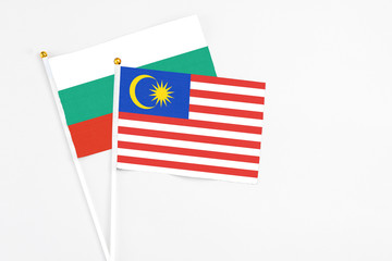 Malaysia and Bulgaria stick flags on white background. High quality fabric, miniature national flag. Peaceful global concept.White floor for copy space.