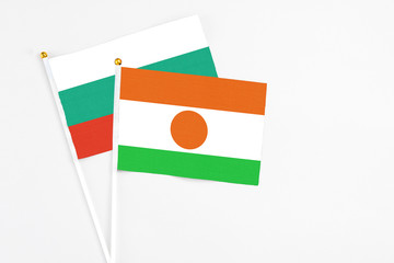 Niger and Bulgaria stick flags on white background. High quality fabric, miniature national flag. Peaceful global concept.White floor for copy space.