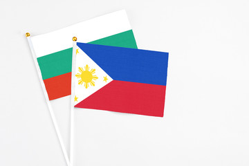 Philippines and Bulgaria stick flags on white background. High quality fabric, miniature national flag. Peaceful global concept.White floor for copy space.