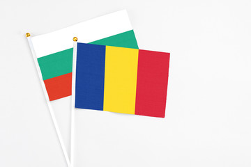 Romania and Bulgaria stick flags on white background. High quality fabric, miniature national flag. Peaceful global concept.White floor for copy space.