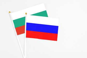 Russia and Bulgaria stick flags on white background. High quality fabric, miniature national flag. Peaceful global concept.White floor for copy space.