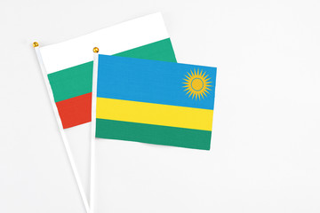 Rwanda and Bulgaria stick flags on white background. High quality fabric, miniature national flag. Peaceful global concept.White floor for copy space.