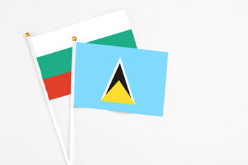 Saint Lucia and Bulgaria stick flags on white background. High quality fabric, miniature national flag. Peaceful global concept.White floor for copy space.