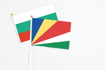 Seychelles and Bulgaria stick flags on white background. High quality fabric, miniature national flag. Peaceful global concept.White floor for copy space.