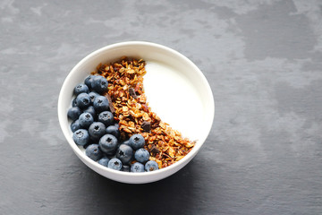 Fototapeta na wymiar Bowl of homemade granola with yogurt and fresh berries