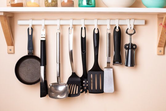 Different kitchen utensils hanging on wall with home decors