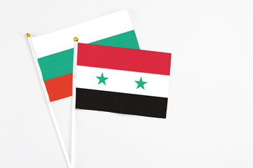 Syria and Bulgaria stick flags on white background. High quality fabric, miniature national flag. Peaceful global concept.White floor for copy space.